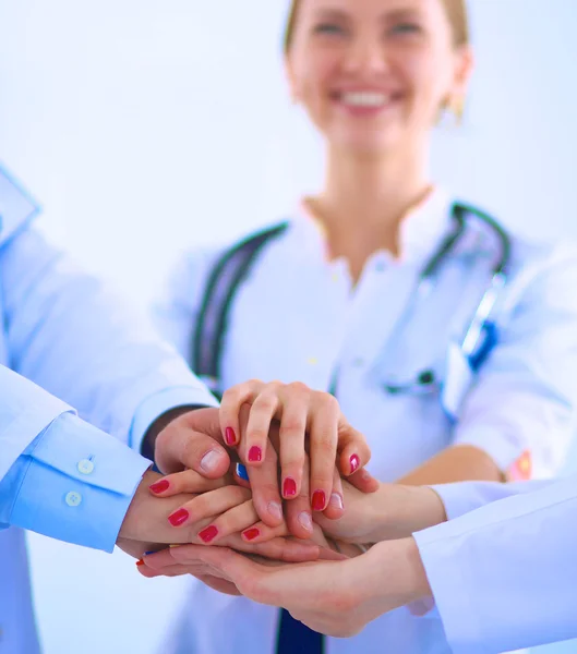 Médicos y enfermeras en un equipo médico apilándose las manos — Foto de Stock