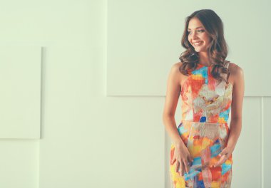 Beyaz arka planda poz veren güzel bir kadın.