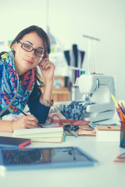 Terzi kadın kağıt üzerinde kıyafet deseni tasarlıyor.