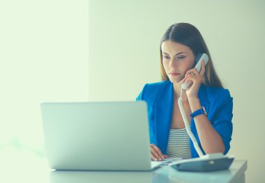 Telefon bir dizüstü bilgisayar önünde genç kadın portre