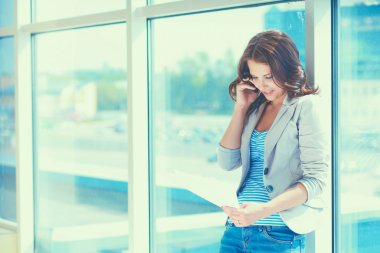 Genç işkadını üstünde hareket eden telefon ofis koridorunda konuşurken portresi