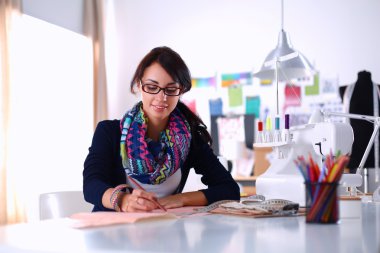 Terzi kadın kağıt üzerinde kıyafet deseni tasarlıyor.