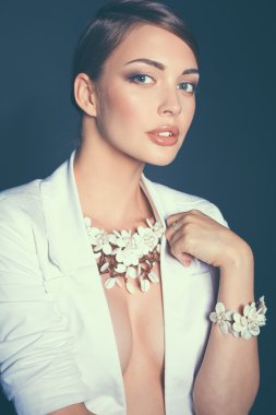 Boncuklar, gri arka plan üzerinde duran genç kadın portresi