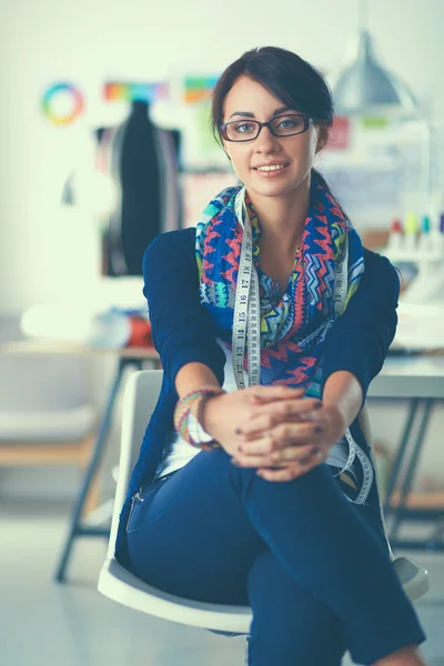 Hermoso diseñador de moda sentado en el escritorio en el estudio — Foto de Stock