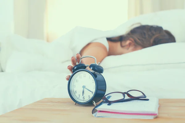 Young woman putting her alarm clock off in the morning — Stock Photo, Image