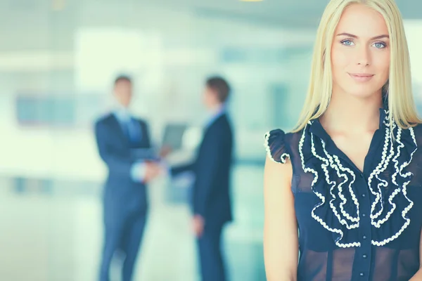 Business woman standing in foreground in office