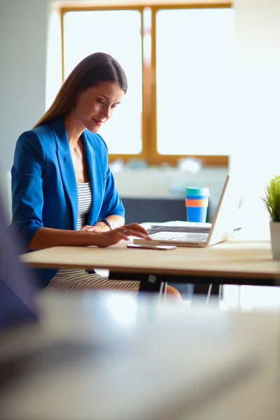 Mulher sentada na mesa com laptop — Fotografia de Stock