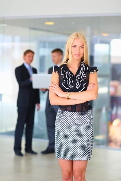 Femme d'affaires debout au premier plan dans le bureau — Photo