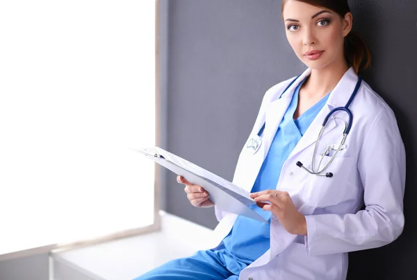 Ärztin mit Stethoskop isoliert auf grauem Hintergrund — Stockfoto