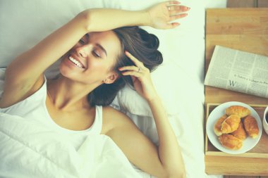 Evde yatakta yatan genç güzel kadın