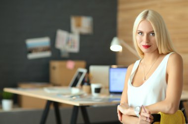 Moda tasarımcıları stüdyoda çalışıyor. Masanın üzerinde oturuyorlar.