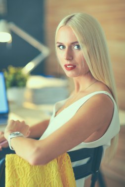 Moda tasarımcıları stüdyoda çalışıyor. Masanın üzerinde oturuyorlar.