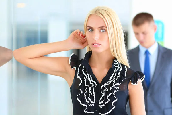 Business woman standing in foreground in office