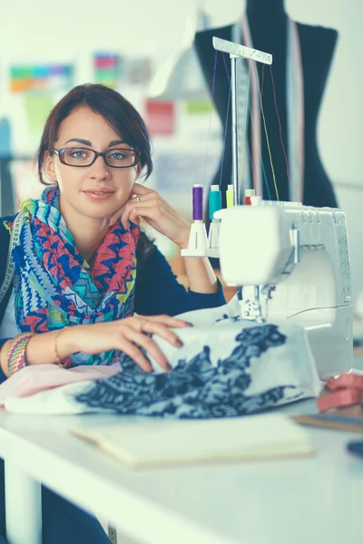 Mujer joven cosiendo sentado en su lugar de trabajo — Foto de Stock