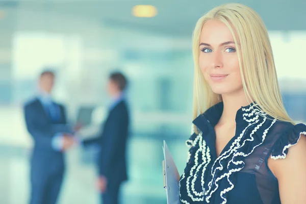 Business woman standing in foreground in office