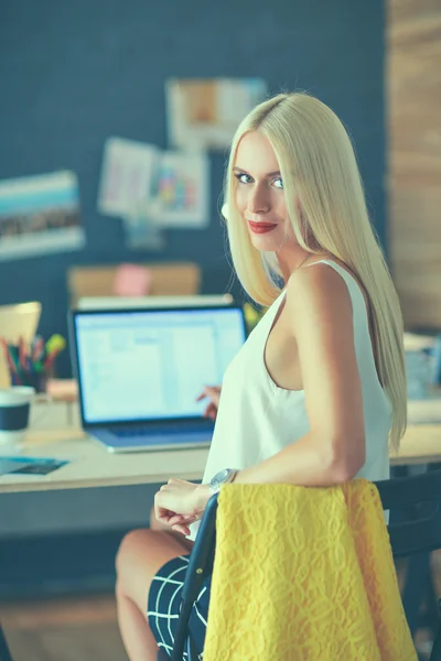 Fashion designers working in studio sitting on the desk — Stock Photo, Image