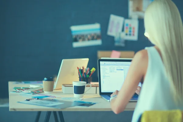 Fashion designers working in studio sitting on the desk — Stock Photo, Image