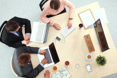 İş adamları toplantıda, ofiste oturup tartışıyorlar.