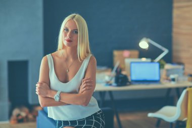 Moda tasarımcıları stüdyoda çalışıyor. Masanın üzerinde oturuyorlar.