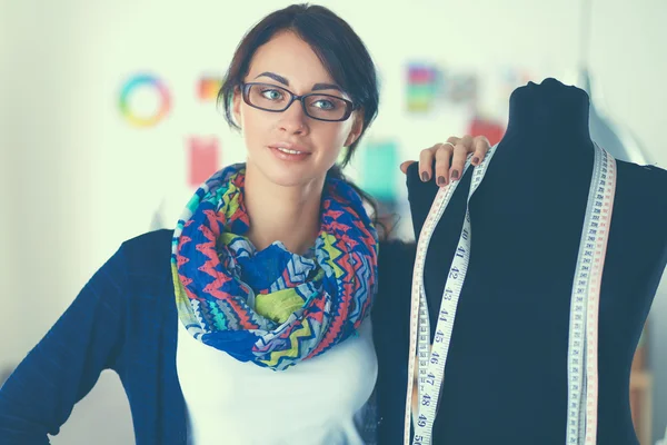 Smiling fashion designer standing near mannequin in office — Stock Photo, Image