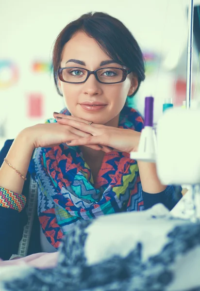 Ung kvinna som syr medan hon sitter på sin arbetsplats — Stockfoto