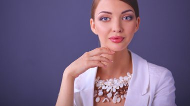 Boncuklar, gri arka plan üzerinde duran genç kadın portresi