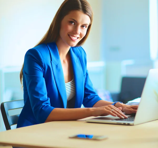 Woman sitting on the desk with laptop. — Stock Photo, Image