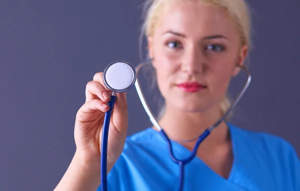 Doctora con estetoscopio escuchando, aislada sobre fondo gris — Foto de Stock