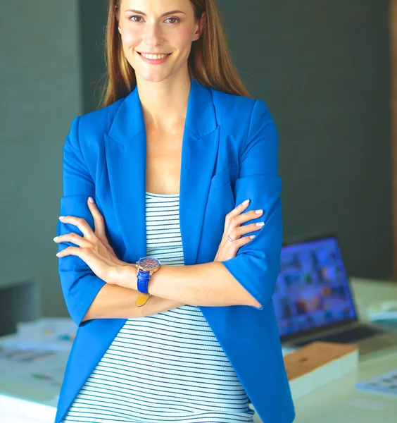 Portret van een mooie zakenvrouw in de buurt van haar werkplek — Stockfoto