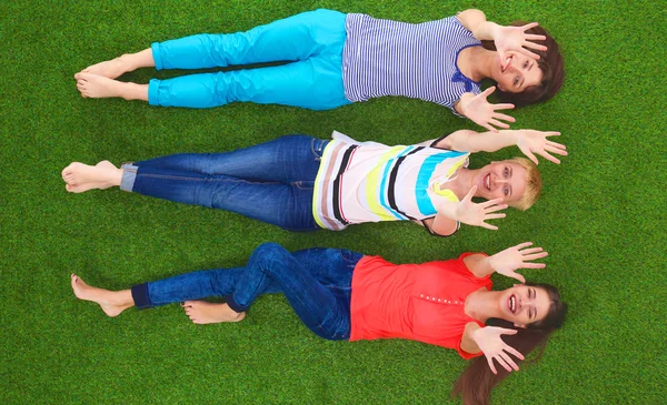 Jonge vrouwen liggend op groen gras — Stockfoto