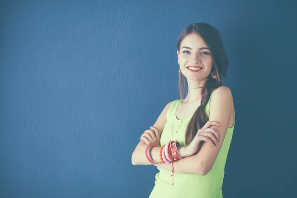 Young woman standing near dark wall with crossed hand — Stock Photo, Image