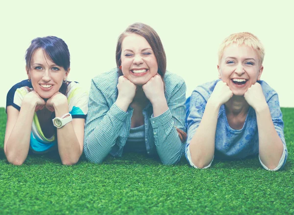 四名年轻女子躺在绿色的草地上 — 图库照片