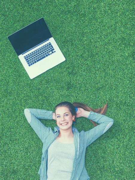 与笔记本电脑草地上轻松的女人 — 图库照片