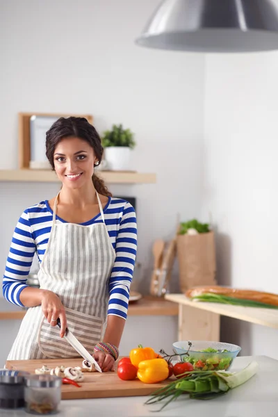 Jovem mulher cortando legumes na cozinha em casa — Fotografia de Stock