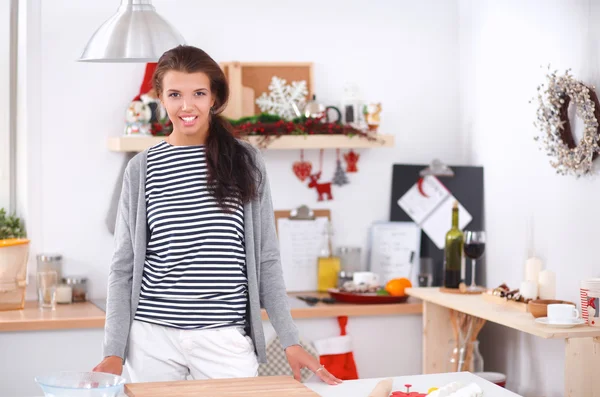 Sorrindo jovem mulher de pé na cozinha — Fotografia de Stock