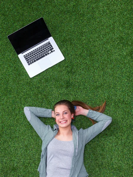 与笔记本电脑草地上轻松的女人 — 图库照片