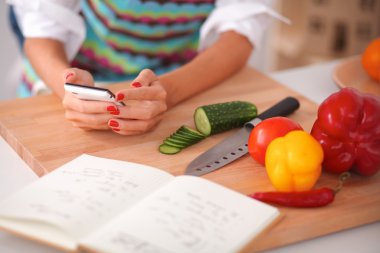 Gülümseyen genç kadın mutfakta salata hazırlık