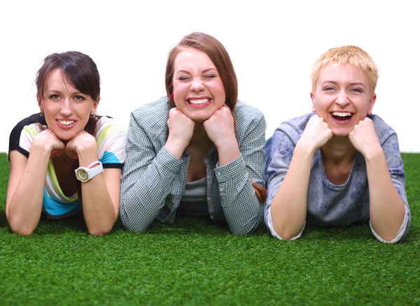 Four young women lying on green grass — Stock Photo, Image