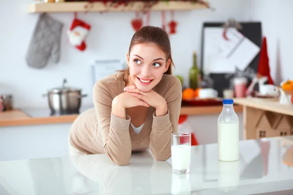 Jeune femme qui sent debout dans sa cuisine — Photo