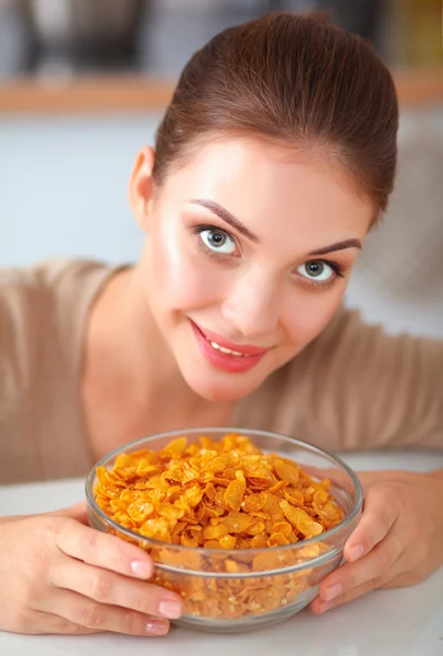 Jeune femme qui sent debout dans sa cuisine — Photo