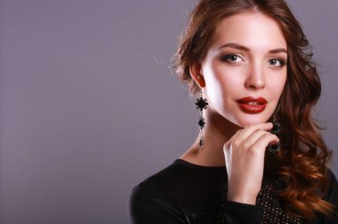 Siyah elbiseli, akşam makyajlı güzel bir kadın.