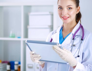 Kadın doktor hastanede dosyayla bekliyor.