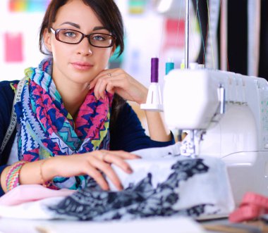 Çalışırken dikiş diken genç bir kadın.