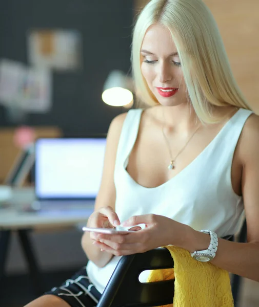 Kvinnan designer med på mobiltelefon i office — Stockfoto