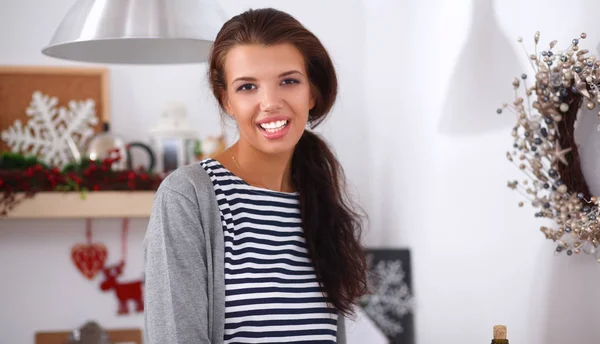 Lächelnde junge Frau steht in der Küche — Stockfoto