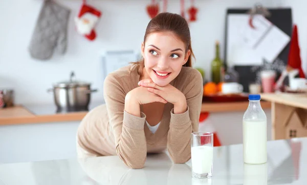 Unga smilling kvinna som står i hennes kök — Stockfoto