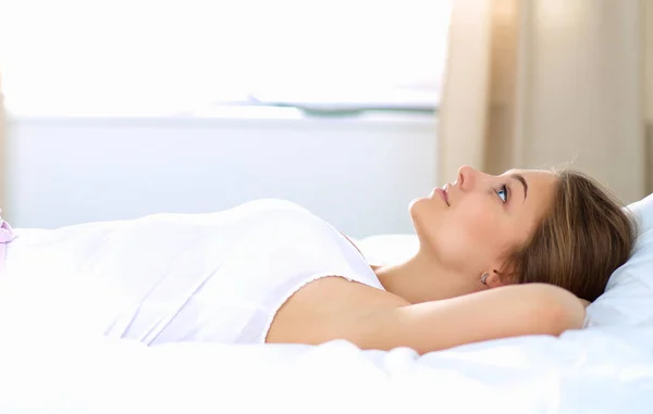 Beautiful young woman lying in bed comfortably and blissfully — Stock Photo, Image