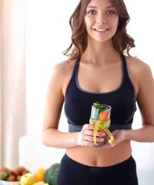 Bir içme tutan kadın taze meyve salatası gözlük çevresinde şerit metre ile dolu cam