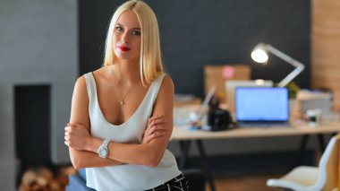 Moda tasarımcıları stüdyoda çalışıyor. Masanın üzerinde oturuyorlar.