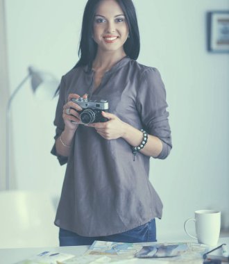 Masada dizüstü bilgisayarla oturan kadın fotoğrafçı.